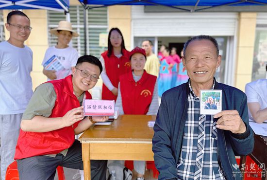 “溫情照相館”攤位上，前來照相的老人與志愿者開心地合影留念_副本.jpg